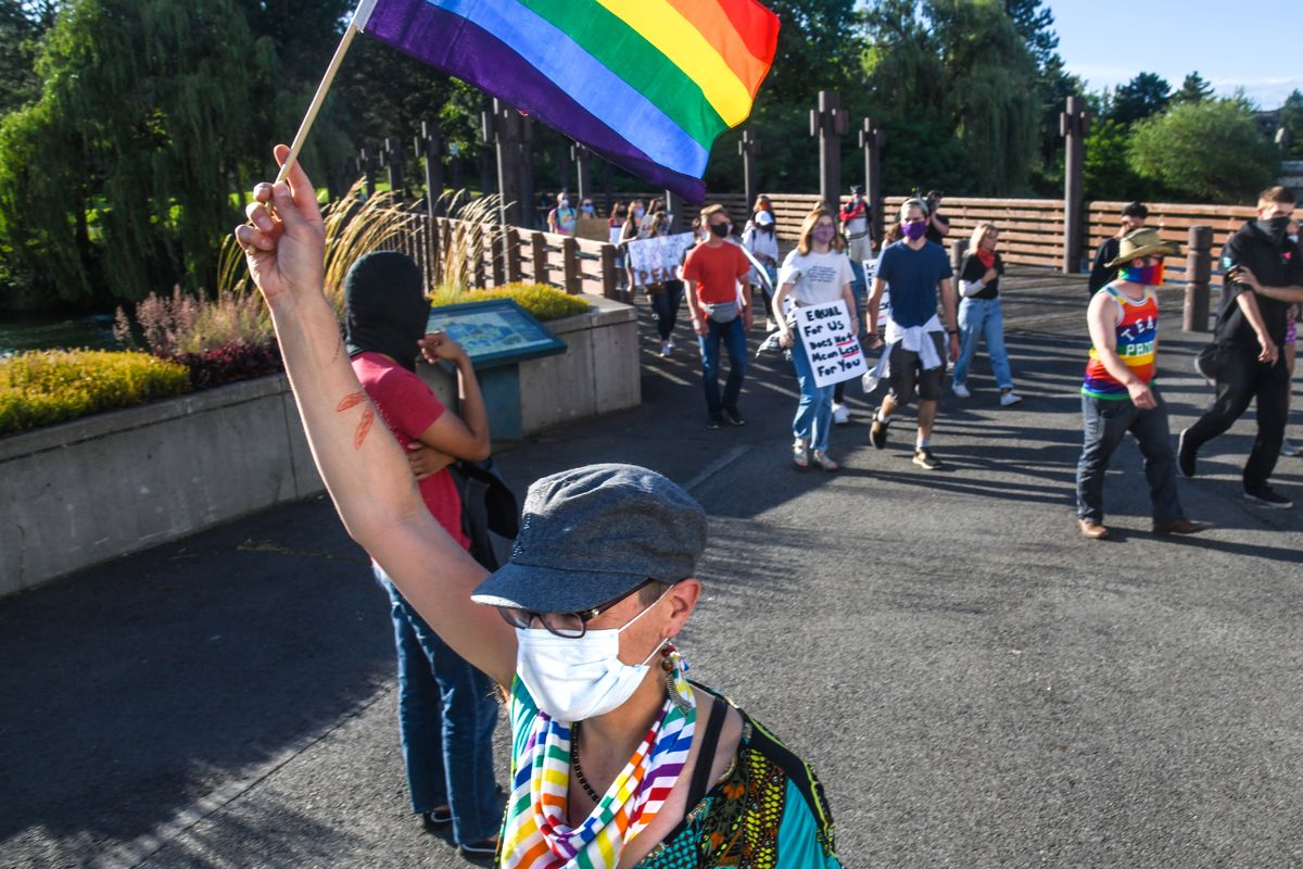 "WE ARE ONE" march participants cross a wooden bridge to meet another group of marchers and proceed along the Centennial Trail into Riverfront Park, Saturday, June 27, 2020, in Spokane.  (DAN PELLE/THE SPOKESMAN-REVIEW)