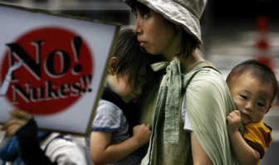 A protester carries toddlers as she marches in an anti-nuclear rally Saturday in Tokyo  ahead of the G-8 summit. Associated Press
 (Associated Press / The Spokesman-Review)