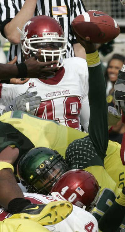 
Oregon quarterback Dennis Dixon holds up the ball from the bottom of the pile after a TD. Associated Press
 (Associated Press / The Spokesman-Review)
