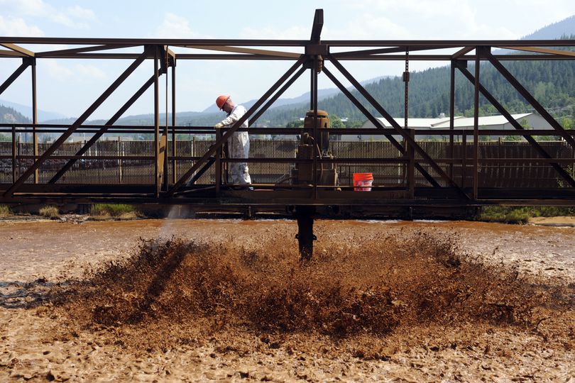 Tim Little stands over a churning tank of mining wastewater as it is aerated and neutralized by the addition of lime at the Central Treatment Plant in Kellogg.  (Jesse Tinsley)