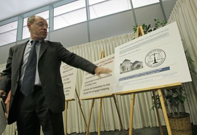 Federal Trade Commission Chairman Jon Leibowitz points to a display of an advertisement that appears to be a government agency, but is actually a scam, as he announces lawsuits to shut down large-scale loan modification scams in Los Angeles and Orange counties, at a news conference in Los Angeles on Wednesday. (Associated Press / The Spokesman-Review)