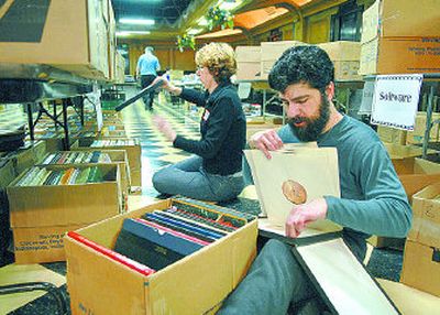 
Volunteers Abram Klebandoff  and Kathy Bentley sort through boxes of classical albums Friday in the Masonic Center. 
 (Dan Pelle / The Spokesman-Review)