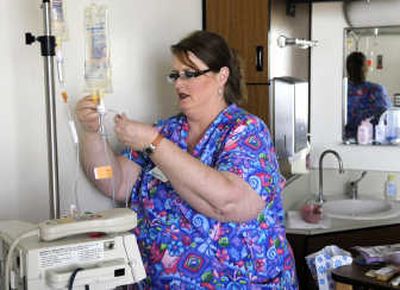 
Nurse Cheri Legaard, of Coeur d'Alene, tends to an  IV during her rounds Friday on the 10th floor at Deaconess Medical Center. 
 (Dan Pelle / The Spokesman-Review)