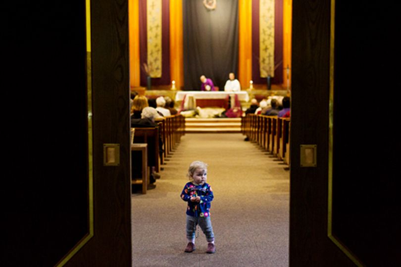 Toddler Eloise Elgee pauses from exploring the chapel during her first Ash Wednesday ceremony at St. Pius X Catholic Church in Coeur d'Alene. Ash Wednesday marks the first day of the season of Lent according to the Catholic religion. (Shawn Gust/press)