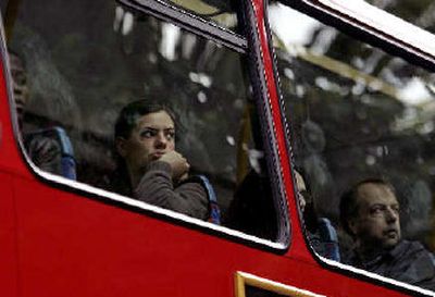
Commuters traveling on a double-decker bus Friday watch the scene of a similar bus that was hit by an explosion Thursday outside Russell Square underground station in central London.
 (Associated Press / The Spokesman-Review)