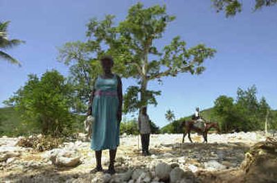 
Residents of the village of Cayes Didier, near Mapou, about 30 miles southeast of Port-au-Prince, Haiti, walk by a mapou tree last week. 
 (Associated Press / The Spokesman-Review)