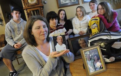 Sue Smith holds a picture of her husband, Rob, on Tuesday at his parents’ home near Colbert. Rob Smith  died Friday in a snowmobile accident. Behind Smith are, from left: Rob Smith’s son Ryan Smith; his stepson Cameron Moors; his daughters Shea Smith and Erica Cease; and Sue Smith’s daughters Sara Overfelt and Emily Overfelt.   (Dan Pelle / The Spokesman-Review)