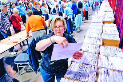 
Volunteer Vicki Stradley finds a participant''''s race packet during the Bloomsday trade show at the Spokane Convention Center on Friday. More than 40,000 people are expected to start the race Sunday morning in downtown Spokane. 
 (Dan Pelle / The Spokesman-Review)
