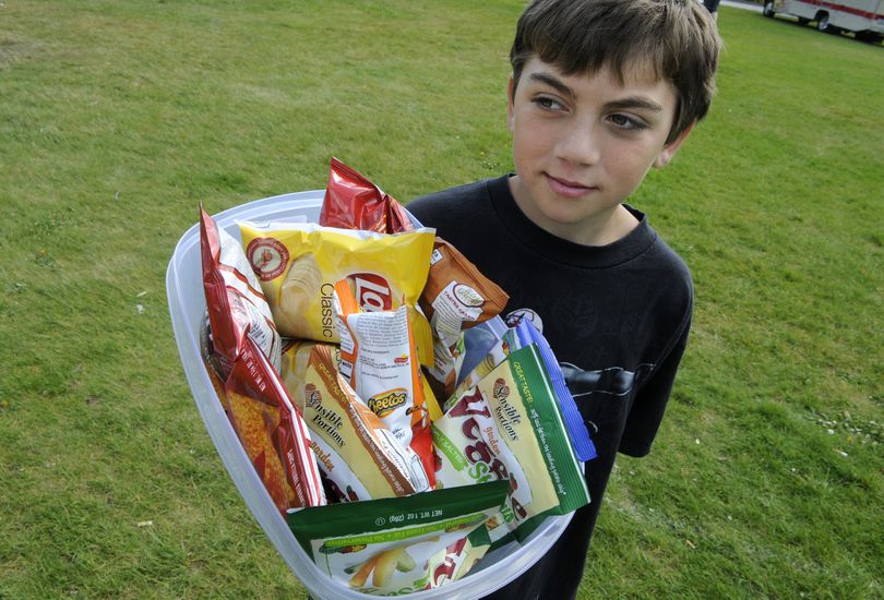 Jon Coggin, 10, sells chips for $1 to raise money for Carissa Outen on May 19, 2010, at the Spokane Community College Spring Fling Car Show. (Dan Pelle / The Spokesman-Review)