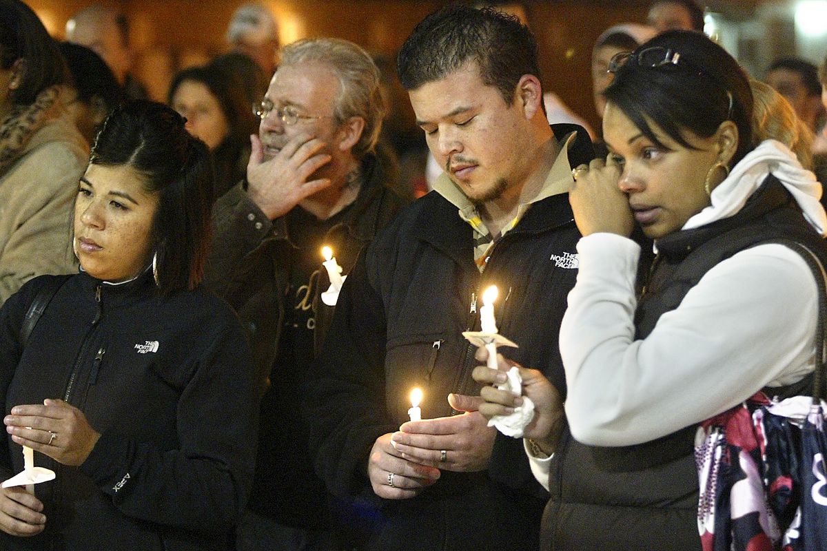 Stephanie James, right, wife of a Lakewood police officer, wipes a tear during a candlelight vigil held Sunday night at the Champions Centre in Tacoma for four Lakewood officers who were fatally shot Sunday morning at a coffee shop in Parkland. (Associated Press)