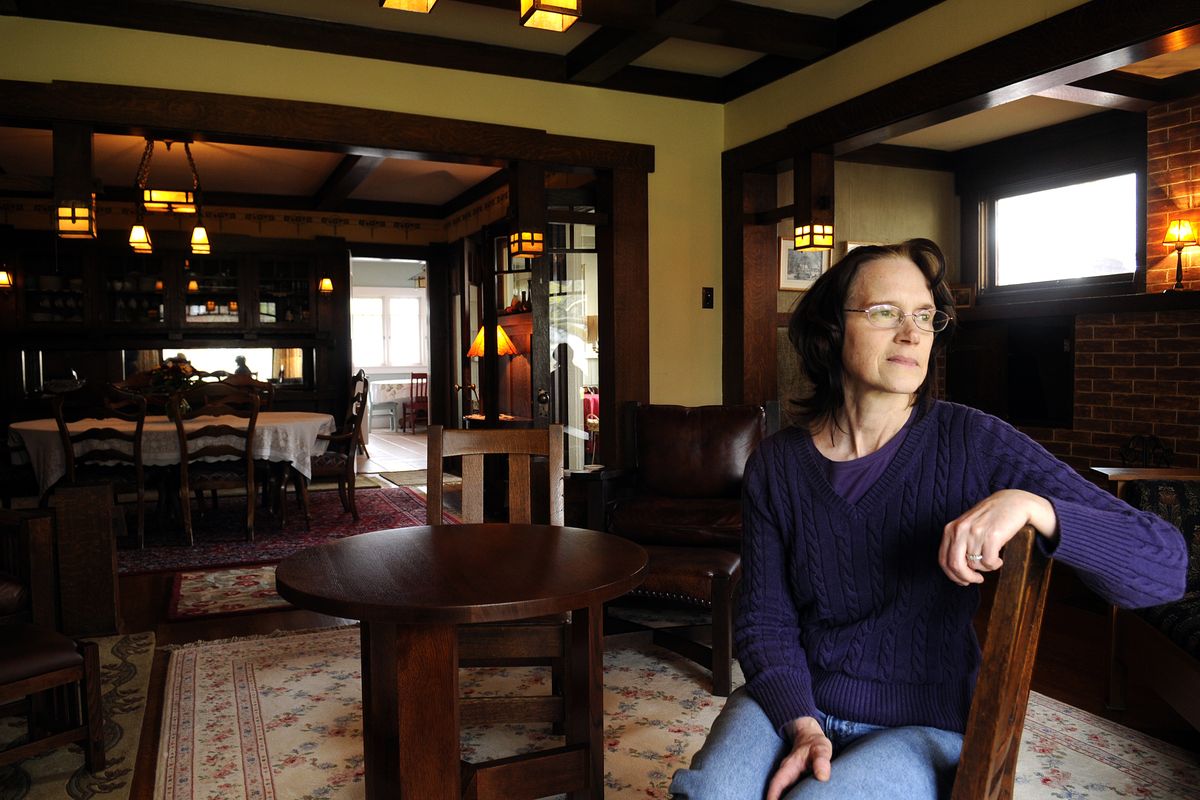 Jill Bray sits in her Craftsman  bungalow-style home on the South Hill on April 27. The house, at 420 W. 22nd Ave., is part of the upcoming Mother’s Day historic tour and is trimmed with lots of oak, a built-in china cabinet and original fixtures. (Jesse Tinsley)