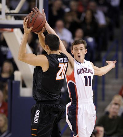 As Pacific Tigers forward Ross Rivera (20) takes a shot Gonzaga Bulldogs guard David Stockton (11) gets a hand on the ball during the first half of a men's WCC college basketball game, Saturday, Jan. 4, 2014, at the McCarthey Athletic Center. (Colin Mulvany / The Spokesman-Review)