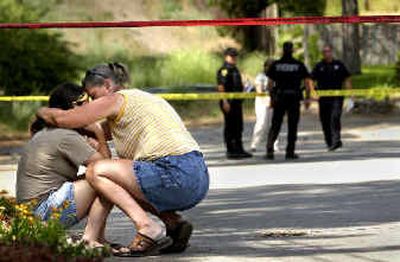 
Jessica A. Napier, left, the driver of a car from which a teenage girl fell off and was rushed to the hospital, is comforted by her mother, who did not wish to be named, at the scene of the accident at Union Street and 21st Avenue in Spokane Valley Thursday afternoon. 
 (Holly Pickett / The Spokesman-Review)