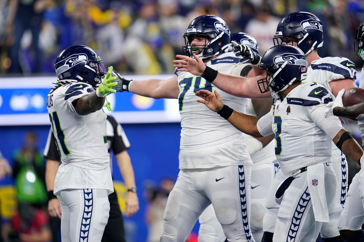 Seattle Seahawks running back DeeJay Dallas, left, celebrates his rushing touchdown with teammates during the second half of an NFL football game against the Los Angeles Rams on Tuesday, Dec. 21, 2021, in Inglewood, Calif.  (Ashley Landis)