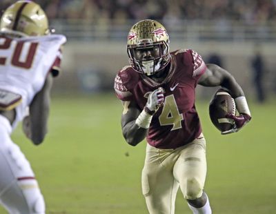 Florida State’s Dalvin Cook picks up yardage as Boston College’s defender Isaac Yiadom moves in for the tackle in the first half of an NCAA college football game, Friday, Nov. 11, 2016, in Tallahassee, Fla. (Steven Cannon / Associated Press)