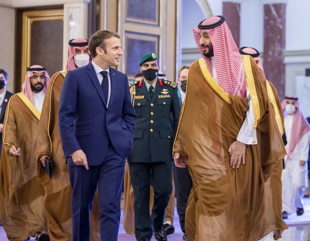 In this photo released by Saudi Royal Palace, Saudi Crown Prince Mohammed bin Salman greets French President Emmanuel Macron, left, upon his arrival in Jiddah, Saudi Arabia, Saturday, Dec. 4, 2021.  (Bandar Aljaloud)