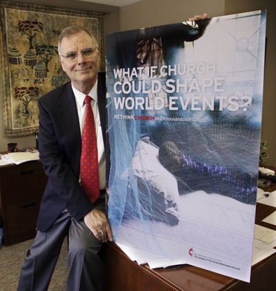 In this May 11 photo, the Rev. Larry Hollon displays a large version of a print ad in Nashville, Tenn., that the United Methodist Church is running as part of a marketing campaign in print, new media, and on radio and television.  (Associated Press / The Spokesman-Review)