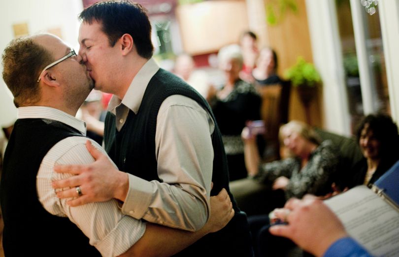 Chris Henry, left, and Chase Lawrence embrace and kiss during their wedding ceremony in front of friends early Sunday morning at a friend’s home near Medical Lake. (Tyler Tjomsland)