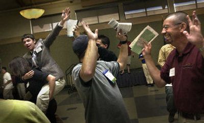 
Investors throw their hands in the air to say no more deals in the last seconds of trading as Mark Alford of Inglemoor High School waves while he rides on the back of Sara Sweeney of Riverside High School to prompt last second sales during the 23rd annual Business Week at Gonzaga University. 
 (Jed Conklin / The Spokesman-Review)