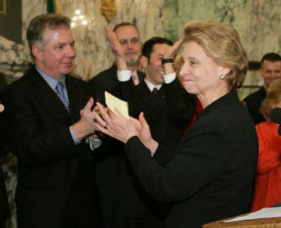 
Gov. Chris Gregoire turns and applauds supporters of legislation to extend civil rights protection to gays and lesbians as Rep. Ed Murray, D-Seattle, looks on in Olympia. The Washington Senate approved the bill Friday by a vote of 25-23.
 (Associated Press / The Spokesman-Review)