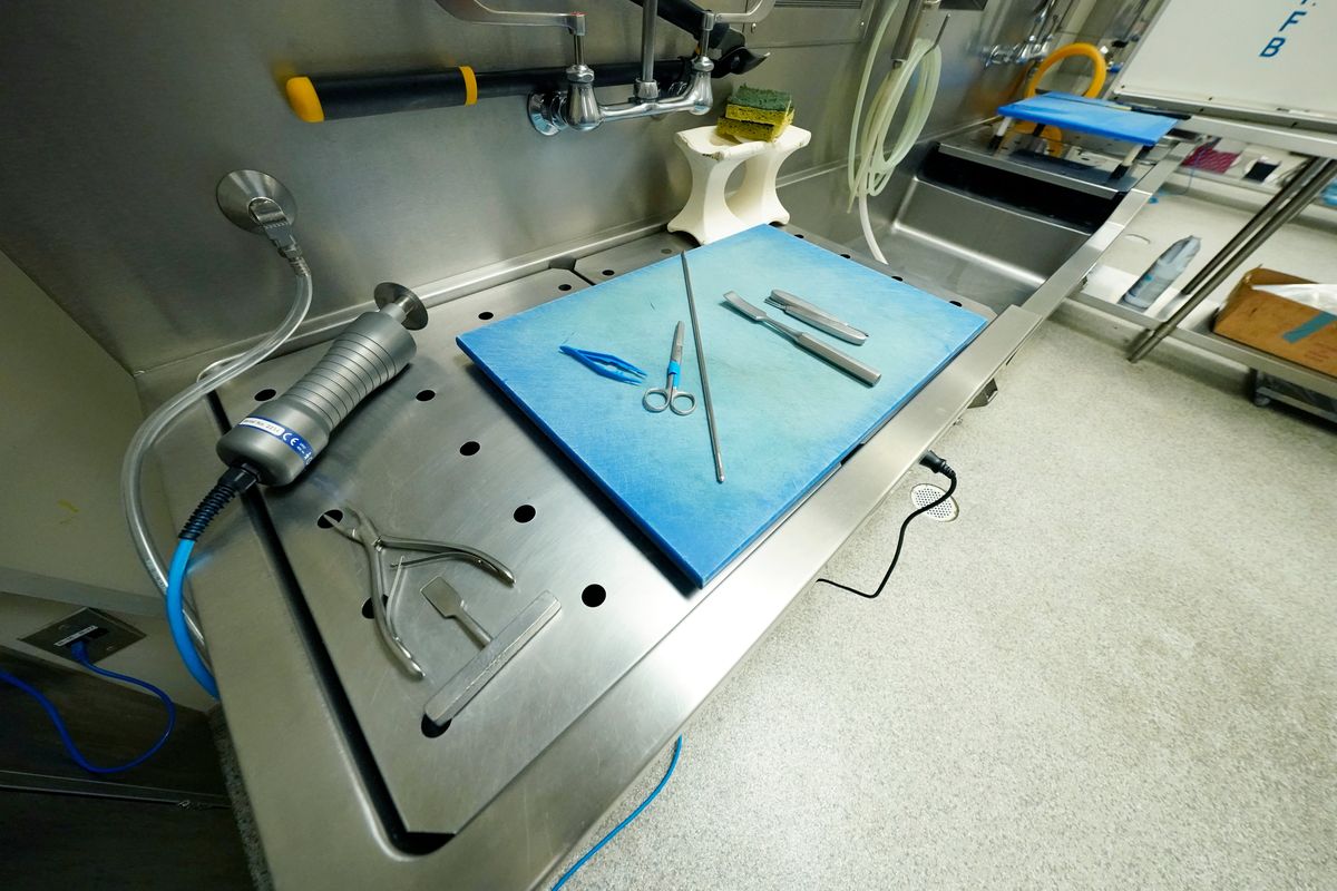 Rib sheers, a new autopsy saw, a set of forceps and tweezers are arranged in one of the four autopsy bays at the Mississippi Crime Laboratory in Pearl, Miss., Aug. 26, 2021.  (Rogelio V. Solis)