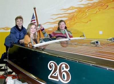 
Tinka Schaffer, left, with Kelly Condon, center, and Brenna Condon show off the wooden speedboat donated by John and Wanda Condon for the Children's Village Annual Charity Auction and Dinner April 14. 
 (Photo by Mike Kincaid Handle Extra / The Spokesman-Review)