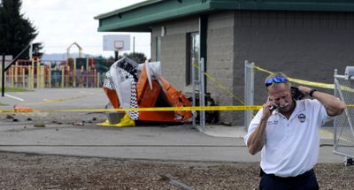 Coeur d’Alene Fire Department Deputy Chief Jim Washko makes a phone call Friday near the scene of a fatal airplane crash at Atlas Elementary School.  (Kathy Plonka / The Spokesman-Review)
