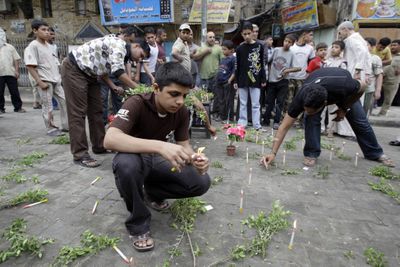 People light candles at the scene of a suicide bombing in a Baghdad  neighborhood Friday. Back-to-back  bombings killed at least 75  people  outside the city’s most important Shiite shrine.  (Associated Press / The Spokesman-Review)