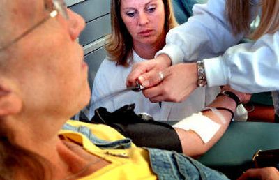 
Phlebotomist Tammie Eubanks talks with Hayden resident Candace Finity as she gives blood at the Inland Northwest Blood Center in Coeur d'Alene. 
 (Kathy Plonka / The Spokesman-Review)