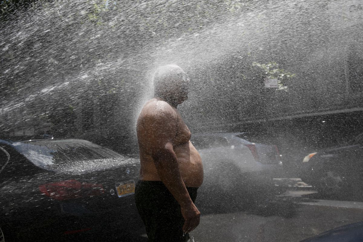 Rey Gomez cools off in the spray from a fire hydrant last summer in New York as the city opened more than 300 fire hydrants with sprinkler caps to help residents cool off during a heat wave.  (Mark Lennihan)