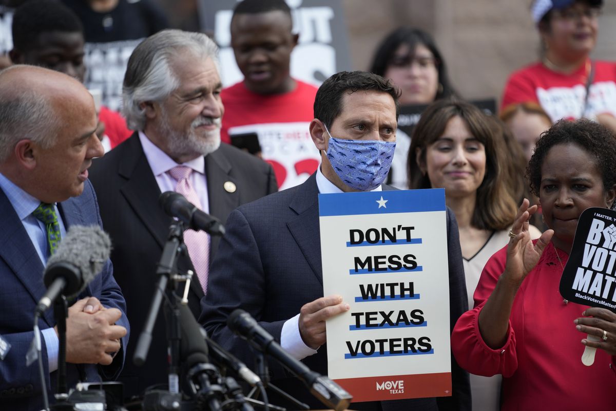 Rep. Trey Martinez Fischer, D-San Antonio, holds a sign as he and other Democratic caucus members join a rally on the steps of the Texas Capitol to support voting rights, Thursday, July 8, 2021, in Austin, Texas.  (Eric Gay)