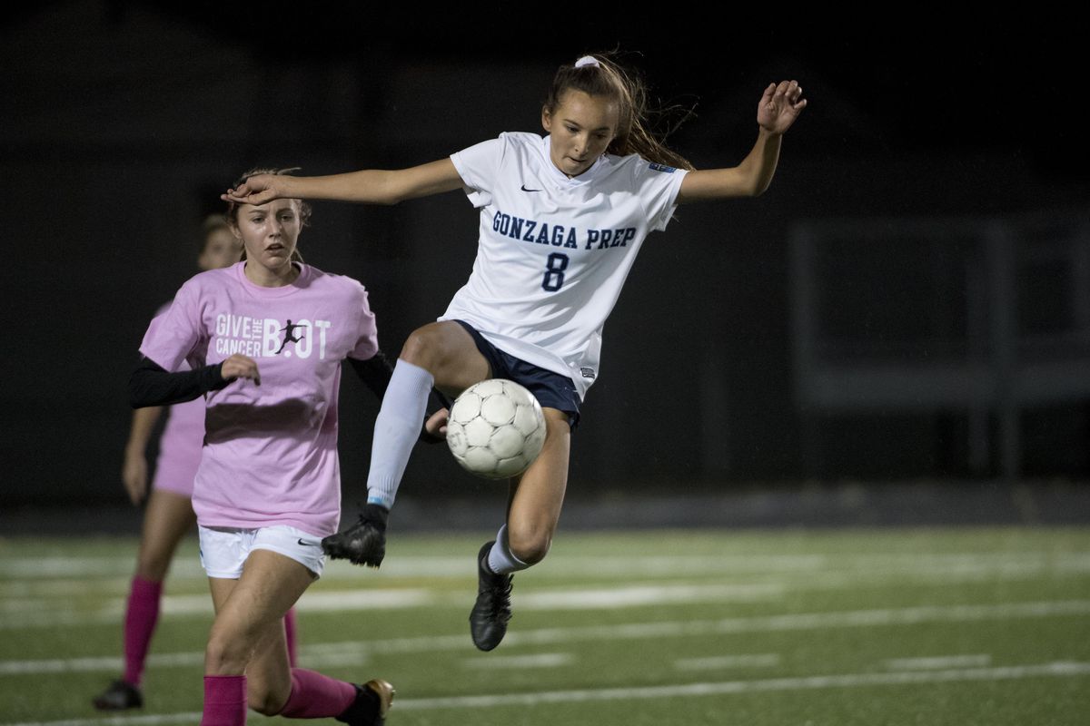 Gonzaga Preps Chelsea Le leaps to intercept a ball in front of Mead’s Katie Kuka in the first half on Wednesday, Oct. 11, 2017 at Gonzaga Prep. (Jesse Tinsley / The Spokesman-Review)