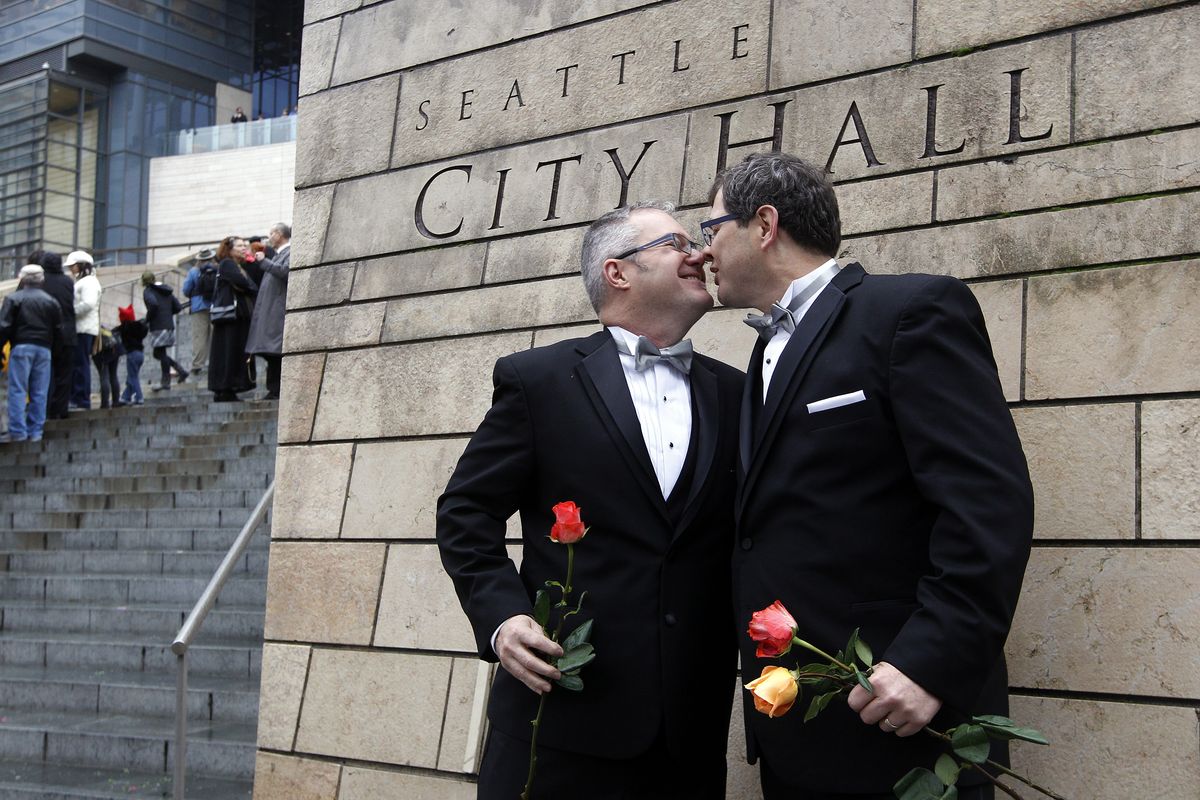Terry Gilbert, left, kisses his husband Paul Beppler after wedding at Seattle City Hall, becoming among the first gay couples to legally wed in the state, Sunday, Dec. 9, 2012, in Seattle. Gov. Chris Gregoire signed a voter-approved law legalizing gay marriage Dec. 5 and weddings for gay and lesbian couples began in Washington on Sunday, following the three-day waiting period after marriage licenses were issued earlier in the week. (Elaine Thompson / Associated Press)