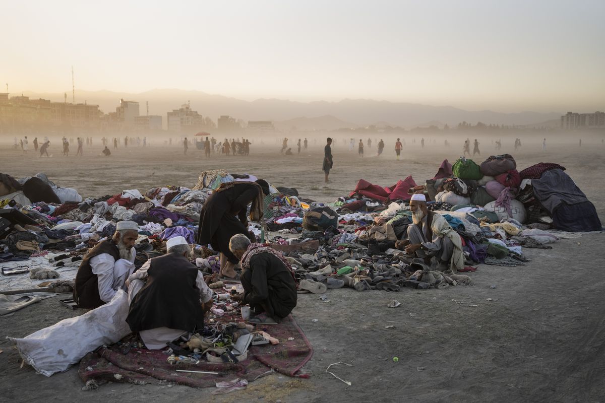 Afghans sort second-hand clothes at the Chaman-e-Hozari Park in Kabul, Afghanistan, Friday, Sept. 17, 2021.  (Bernat Armangue)