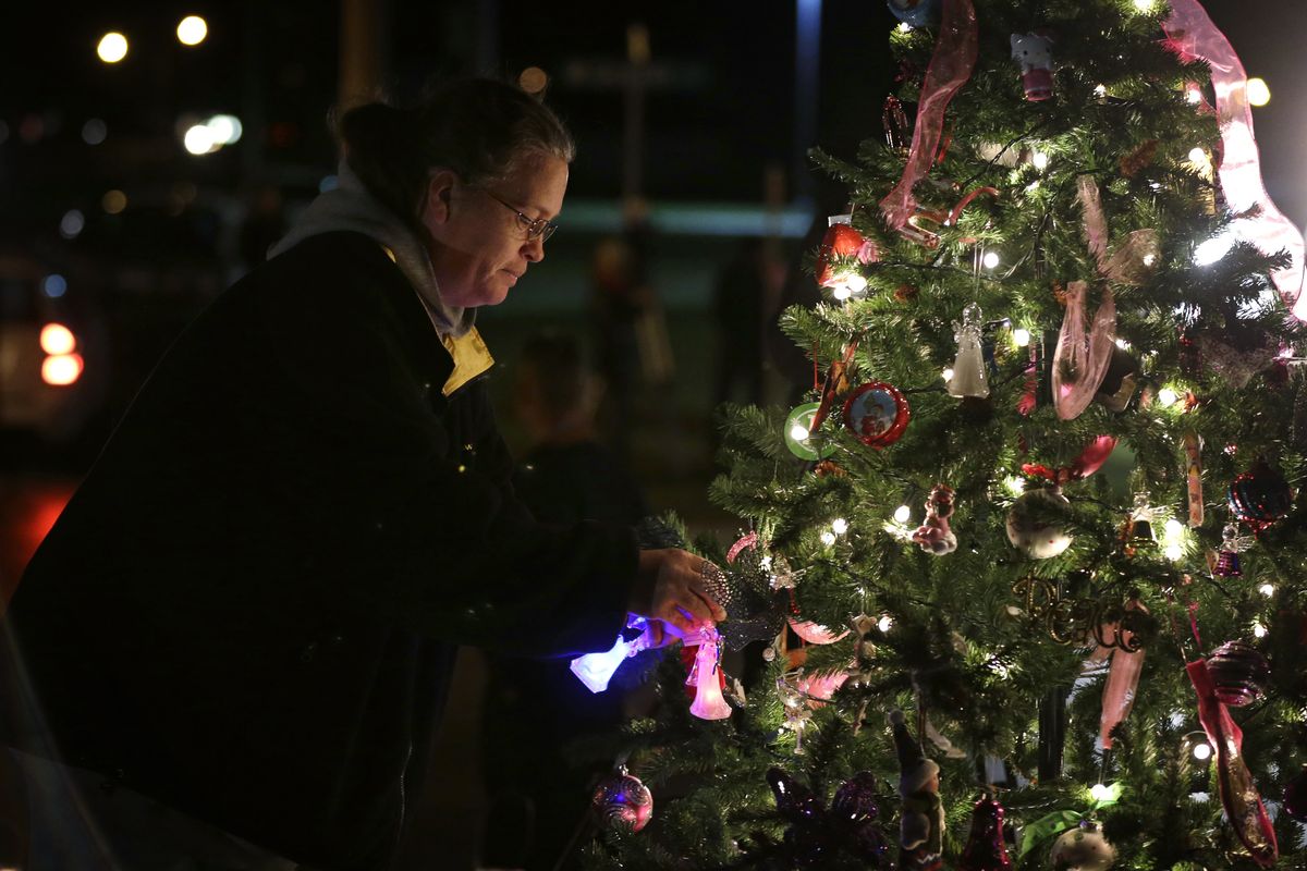 Kelly Borel, of Waterloo, Iowa, puts an ornament on a tree during a vigil for missing cousins Lyric Cook, 10, and Elizabeth Collins, 8, who vanished while riding bikes in Evansdale in July, Thursday, Dec. 6, 2012, in Evansdale, Iowa. Authorities announced Thursday they are confident bodies found in an isolated wildlife area are those of the two girls. (Charlie Neibergall / Associated Press)