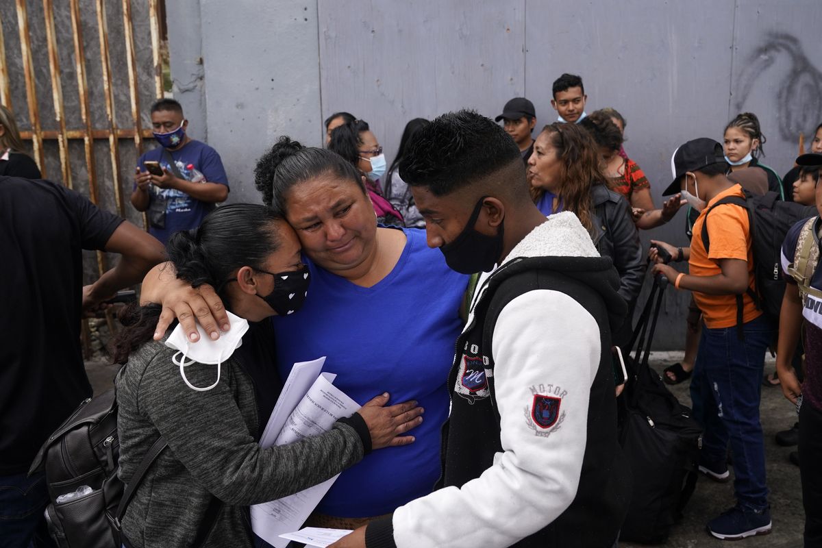 Lizeth Morales, left, of Honduras, and her son, Alex Cortillo, right, get a hug from Erika Valladares Ponce, center, as they wait to cross into the United States to begin the asylum process Monday, July 5, 2021, in Tijuana, Mexico. Dozens of people are allowed into the U.S. twice a day at a San Diego border crossing, part of a system that the Biden administration cobbled together to start opening back up the asylum system in the U.S. Immigration advocates have been tasked with choosing which migrants can apply for a limited number of slots to claim humanitarian protection. (Gregory Bull)