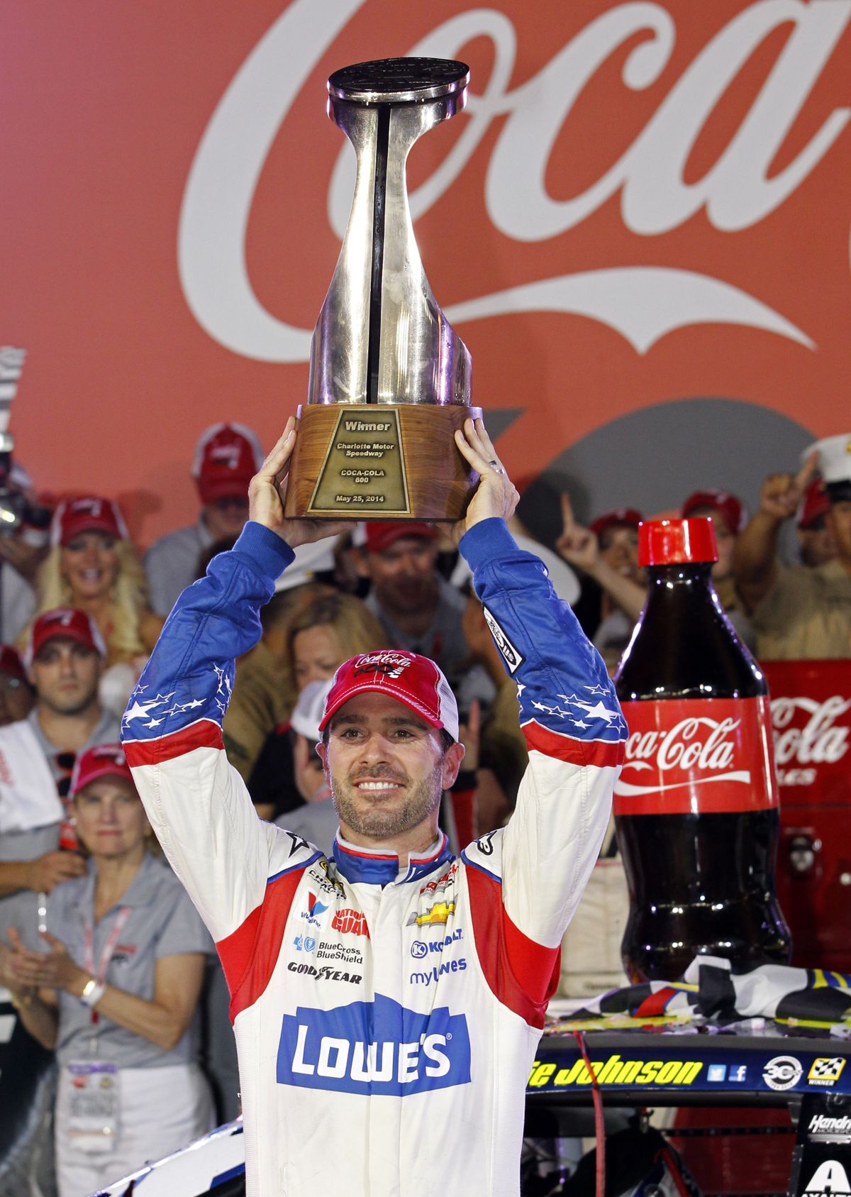 Jimmie Johnson raises the trophy in Victory Lane after winning at Charlotte. (Associated Press)