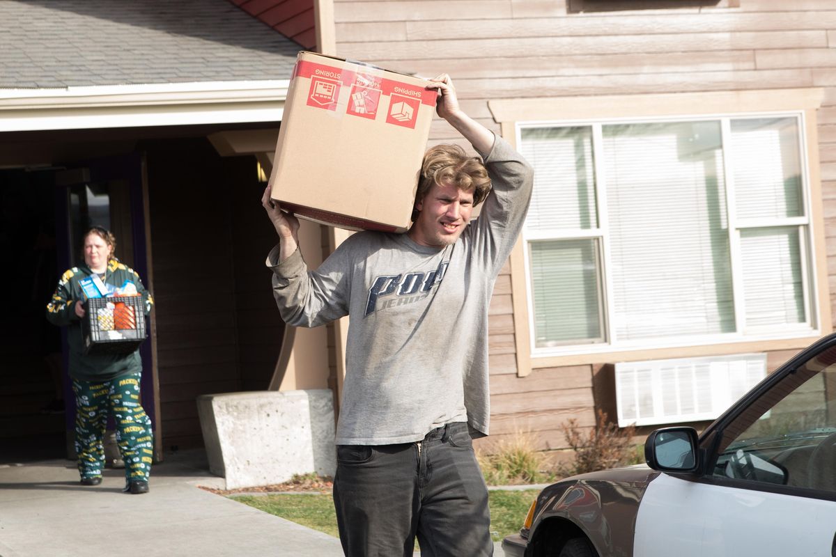 Watson Adric, stepbrother to Kaylajo Chapman-Davis (right) and Tyana Grant, family friend, help move items out of the Walnut Corners apartments at 1403 W. Mallon Ave. on March 17, 2020. The eight-month-pregnant Chapman-Davis was evicted from the unit and locked out of the apartment, eventually receiving one hour to move her belongings out, causing her family and friends to rally to help. (Libby Kamrowski / The Spokesman-Review)