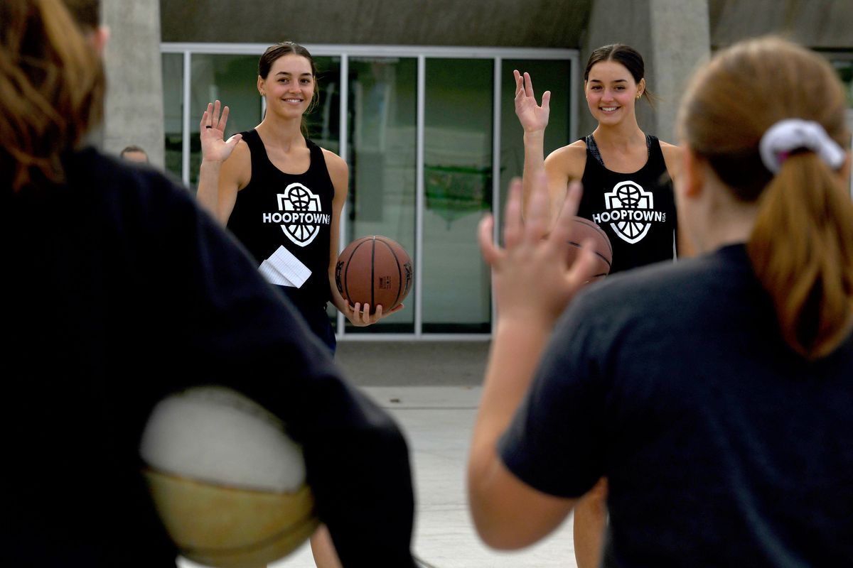 Above: Former Gonzaga basketball players Jenn, left, and LeeAnne Wirth participated in clinics put on by Hooptown USA at the Pavilion at Riverfont Park in May 2021. Below: The twins are pictured during a Gonzaga game on Jan. 9, 2020.  (Kathy Plonka/The Spokesman-Review)