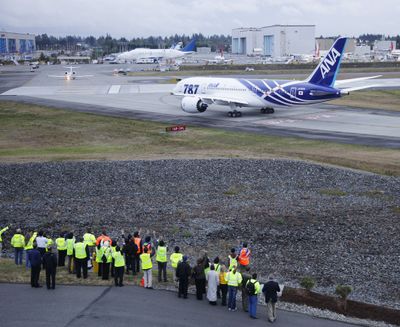 A group of Boeing employees wave as the first Boeing Co. 787 plane delivered to a commercial customer taxis for take off to Japan, Tuesday, Sept. 27, 2011, in Everett, Wash. The plane will be operated by Japan's All Nippon Airways. (AP/Ted S. Warren)