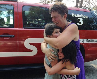 Andrea Watson and her daughter Amanda, 8, hug 9-year-old Brian Watson after being reunited following a search for the boy Wednesday at the beach near North Idaho College. (Shawn Gust/press)