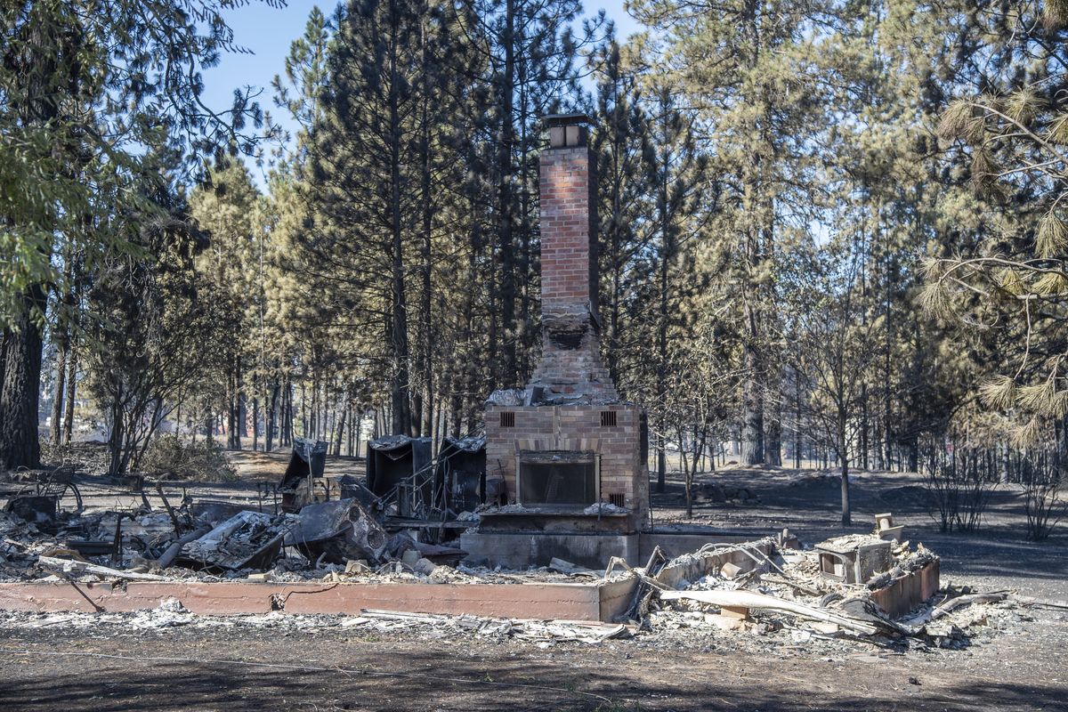 Smoldering remains of one of the many homes burned on Broadway Avenue are seen Sept. 8, the day after a fast-moving wildfire.  (Jesse Tinsley/The Spokesman-Review)