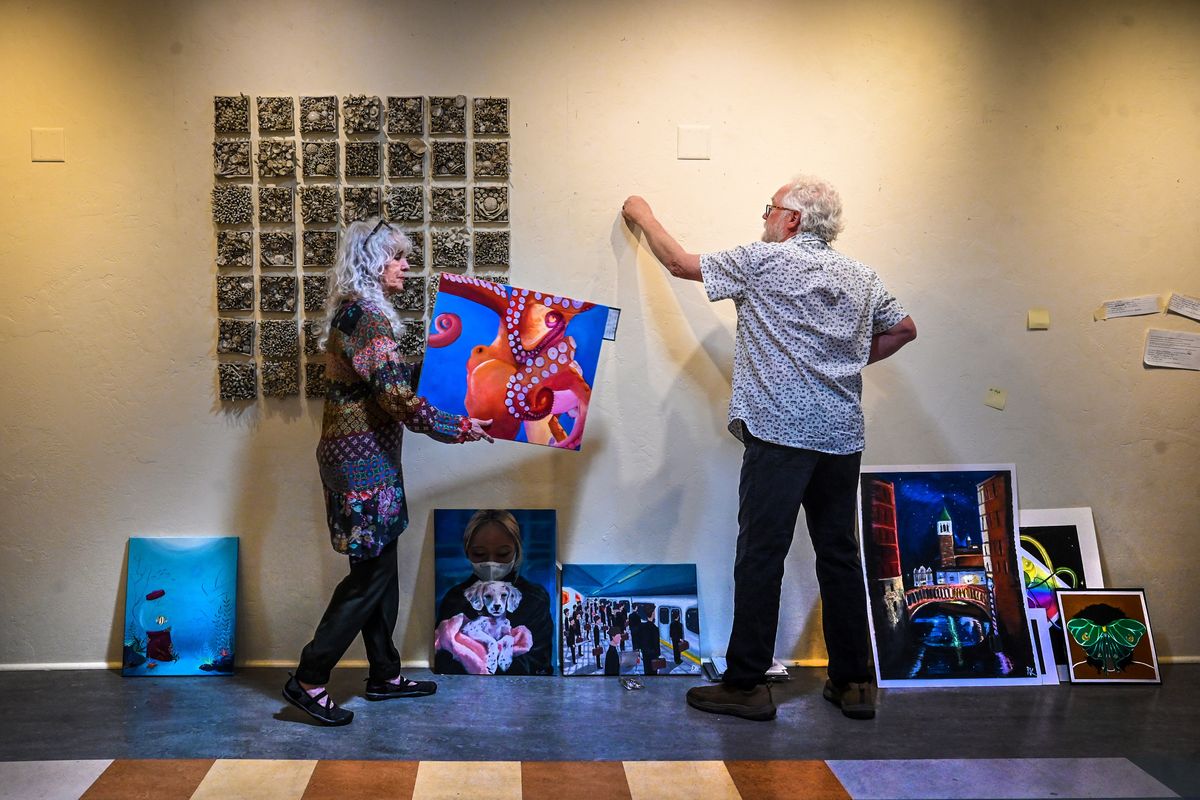 Michele Mokrey and Mark Barnes hang an art piece by Shadle Park High School student Paige Perkins on Monday at the New Moon Art Gallery. The gallery is holding an exhibit showcasing high school art students from Spokane County. Behind Mokrey is a coral reef art project by Rogers High School students.  (DAN PELLE/THE SPOKESMAN-REVIEW)