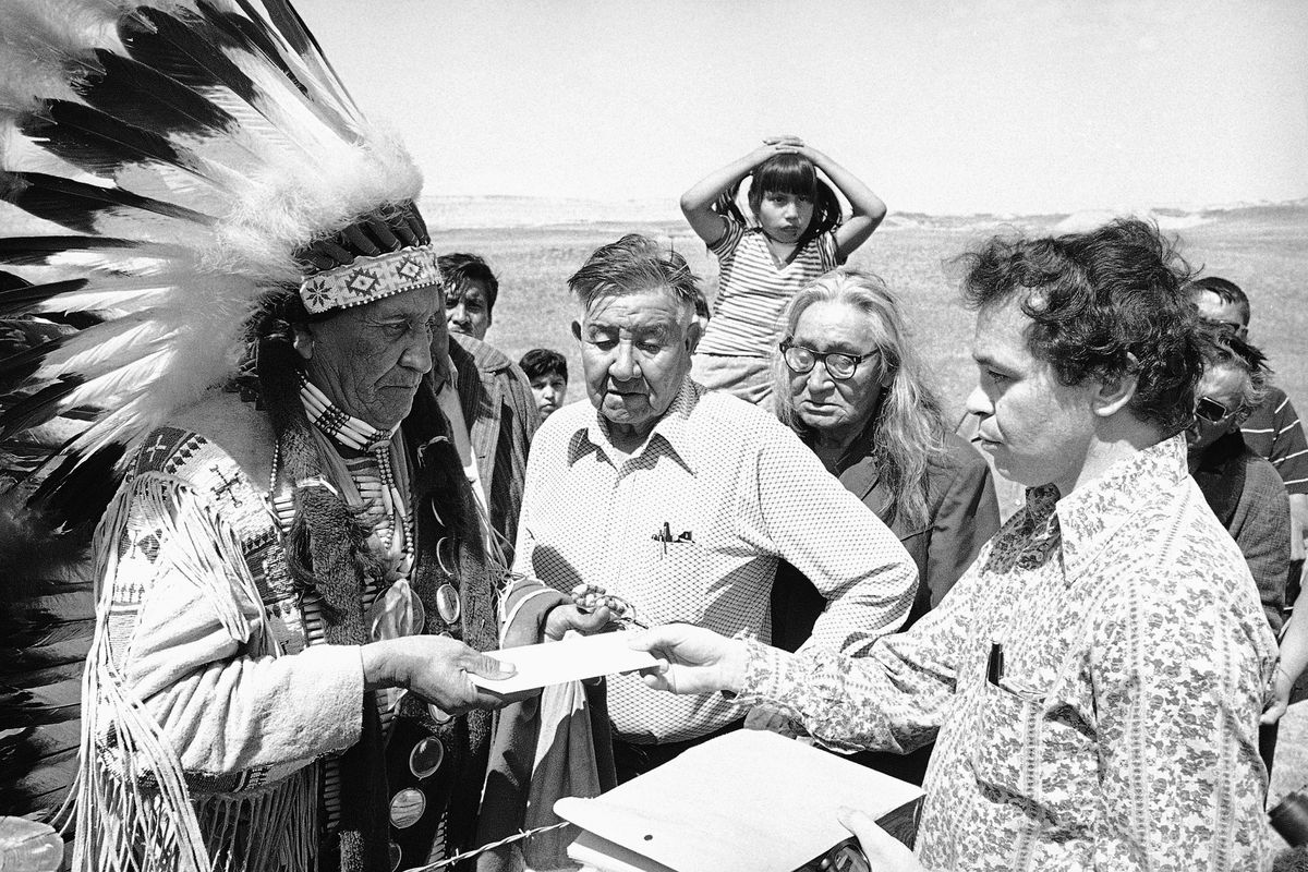 Hank Adams, right, permanent representative of the Indians Trial of Broken Treaties, presents a letter from the White House to traditional Sioux Chief Frank Fools Crow, left, at the border of Pine Ridge Reservation in Scenic, S.D., in May 1973.  (Anonymous)