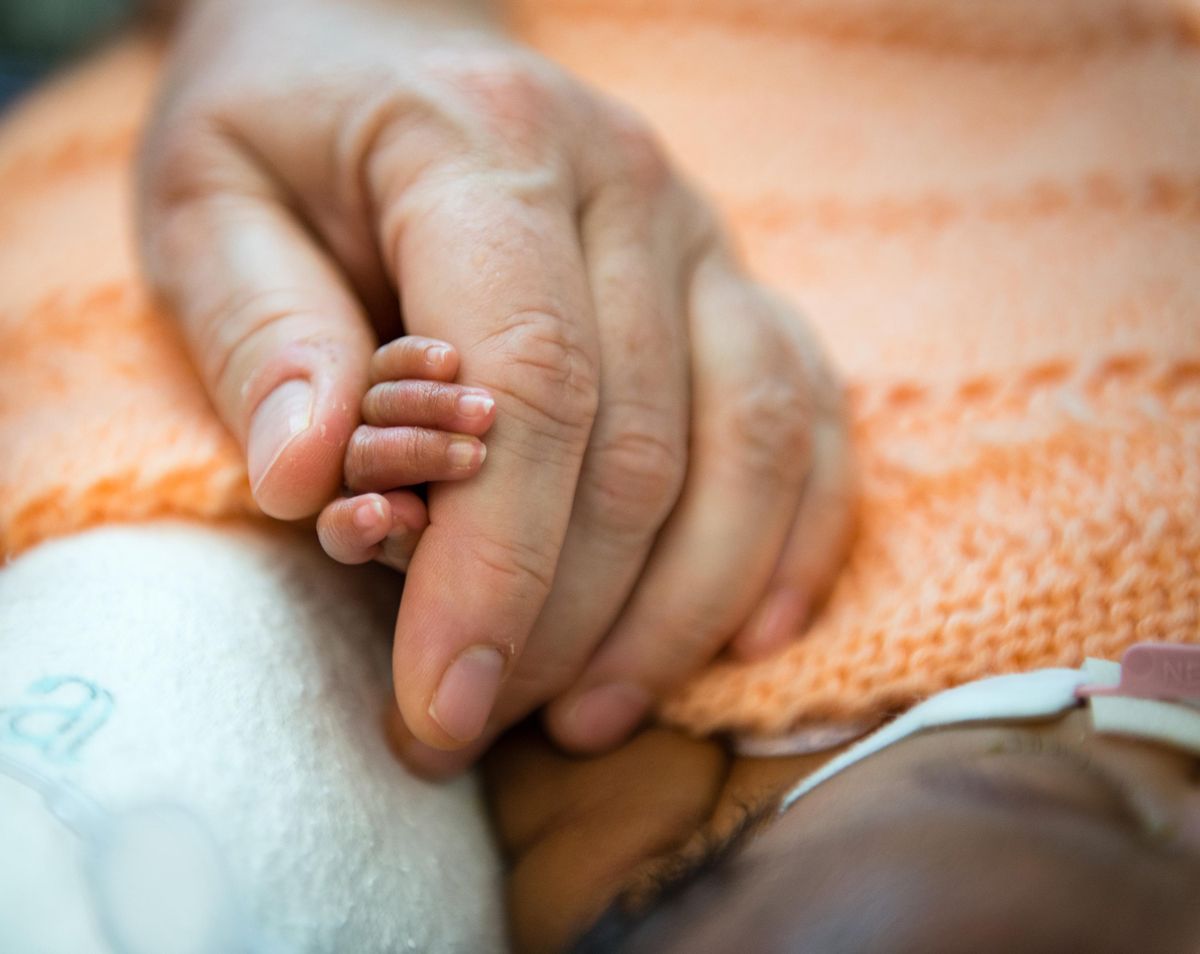 Kate Teague, a registered nurse at Lucile Packard Children’s Hospital in Palo Alto, Calif., holds a premature baby’s hand on Oct. 20.