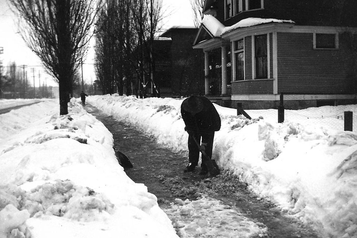 An unidentified man shovels snow from the front of a home near the corner of Sinto Avenue and Monroe Street in Spokane on Jan. 24, 1913.