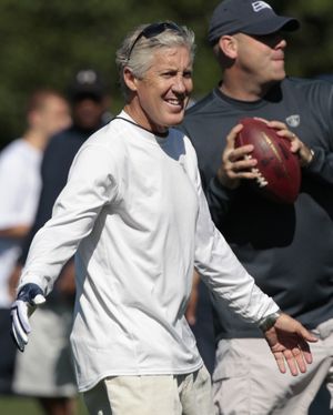 Seattle Seahawks head coach Pete Carroll walks on the field at the start of a walkthrough practice to open NFL football training camp Thursday, July 28, 2011, in Renton, Wash. (Elaine Thompson / Associated Press)