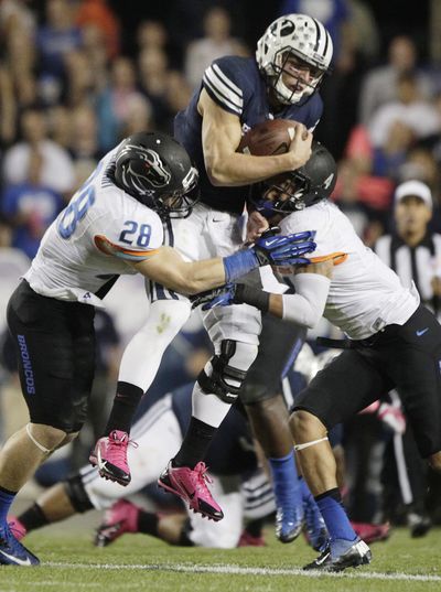 BYU’s Taysom Hill is sandwiched between Boise State’s Dillon Lukehart, left, and Darian Thompson. (Associated Press)