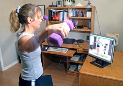 
Michele Galindo exercises with a streaming video from a Web site while in her Austin, Texas home. Experts suggest finding new exercises — or new ways of exercising — to make progress in workouts. Now there are some new alternatives. A handful of companies are offering streaming fitness video online. 
 (AP / The Spokesman-Review)