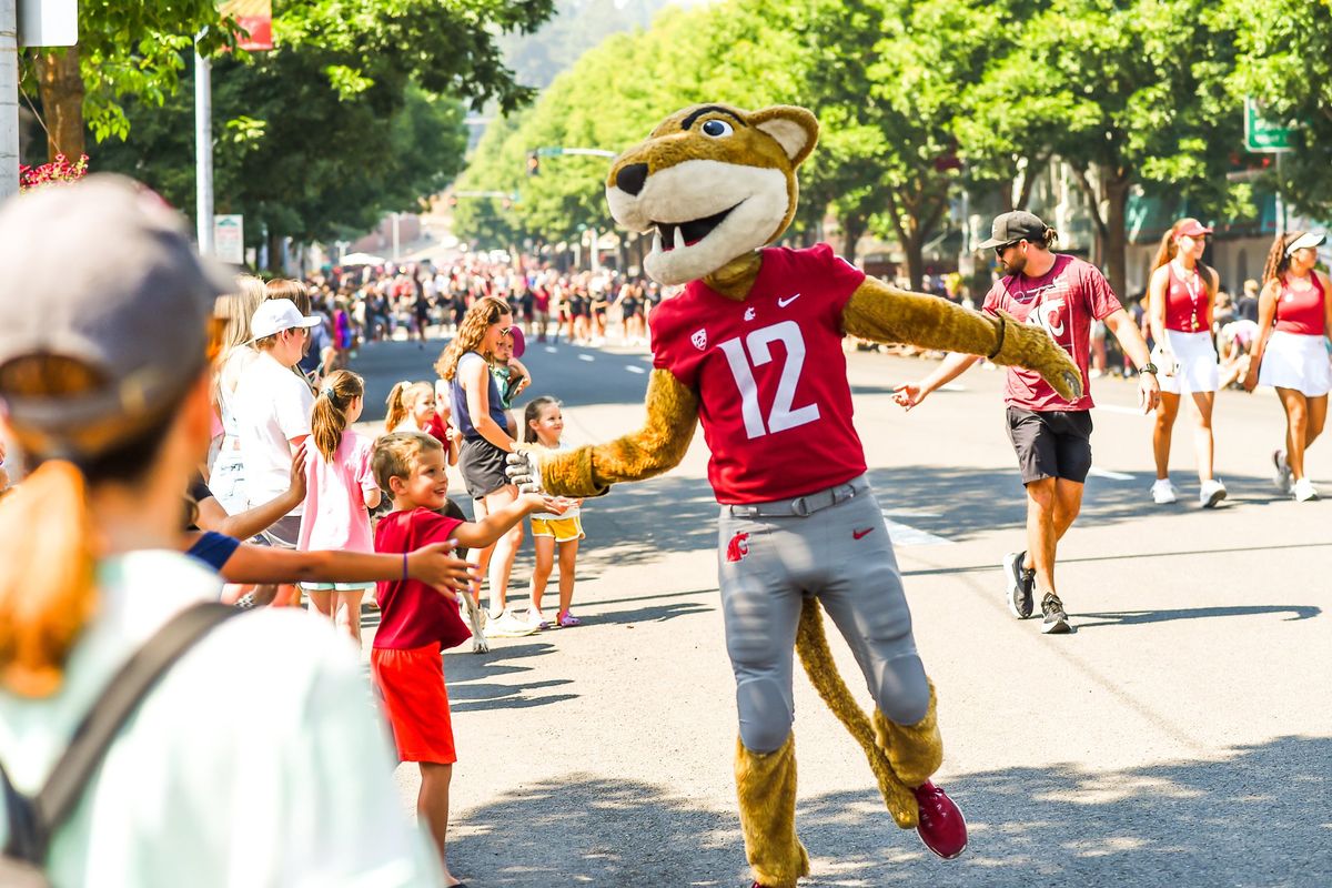 Butch T. Cougar high-fives children along the parade route of the Lentil Festival. This celebration will make its 35th year.  (Courtesy of Lance Lee)